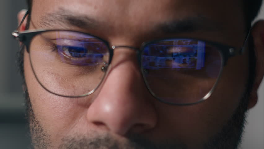 Close up male eyes in eyeglasses laptop monitor light programming codding cyberspace man businessman wear computer glasses reducing eye strain blurred vision looking at pc screen computer reflection Royalty-Free Stock Footage #1104849925