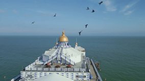 Flying above and over Eastbourne Pier. Birds flying by. Close up view. Shot is taken by dji mini 3 pro drone in Eastbourne England. 4K video