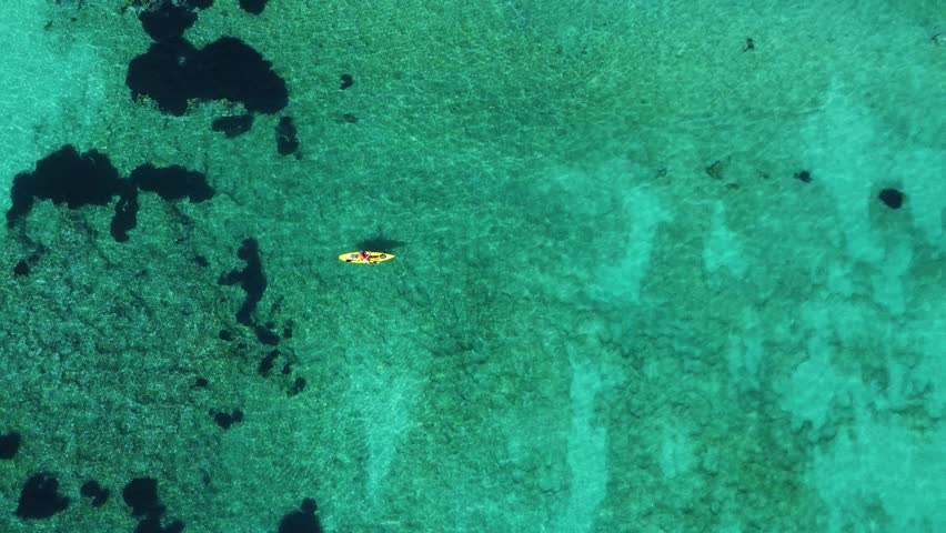 Aerial view of kayaker in the sea fishing in calm turquoise water | Shutterstock HD Video #1104852639