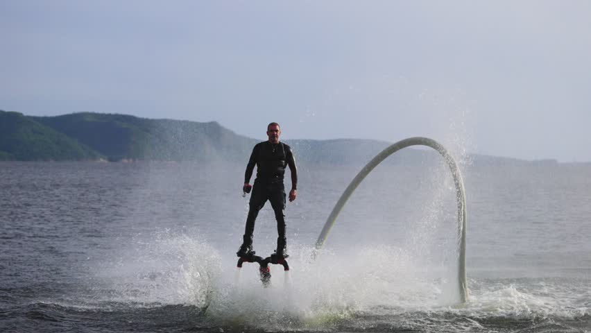An experienced athlete does somersaults over water. Flyboarding is a new extreme sport. Male flywardist doing dangerous stunts. Royalty-Free Stock Footage #1104859689