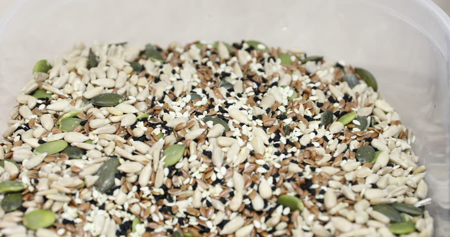 Rolling cookie dough in seeds for healty bread
