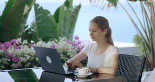 Smiling business woman talk to colleagues on laptop online video conference application, sitting at outdoor cafe while traveling. Digital nomad concept. Woman talking laptop virtual meeting video call