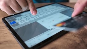 Man enters personal data on tablet screen holding bank card in his hands, close up. Convenience of using a tablet and a bank card to make payments. Contactless payment. - Powered by Shutterstock - Get 15% off with code: PIKWIZARD15