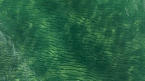 Vertical video, Underwater view on calm surface of blue water. Natural background with surface of blue water. Texture of blue water on surface. Close-up