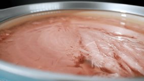 A mesmerizing macro video showcasing the texture, color, and exquisite details of canned tuna, revealing its appetizing and succulent nature.
