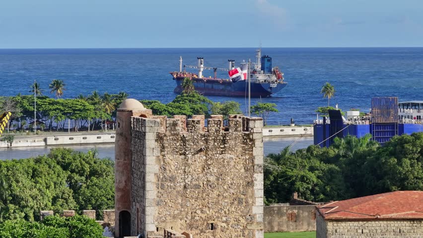 Aerial view Ozama Fortress Castle with waving flag and old Ship on sea in background - Santo Domingo, Dominican Republic  Royalty-Free Stock Footage #1104871837