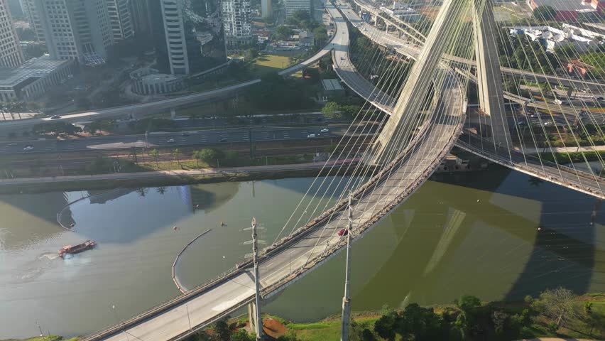 View of the Pinheiros river with modern buildings beside it and the famous Octavio Frias de Oliveira bridge in the city of São Paulo.