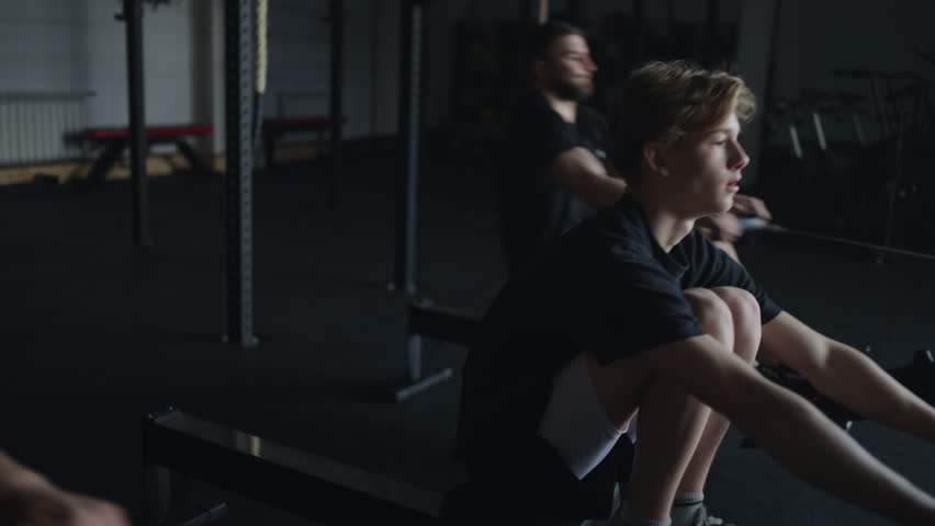 Teen Boy And Young Men Training In Gym, Exercise Machine For Muscles Of Arms And Abs