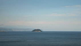Timelapse of a seascape with an island at sunset. View of the Italian Riviera island in summer. Italian Riviera, Liguria, Italy