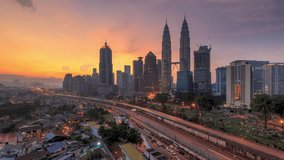 High angle aerial time lapse video of sunrise overlooking an urban village with busy expressway against Kuala Lumpur city skyline in Malaysia. No Logo. High quality, Prores Full HD Time lapse