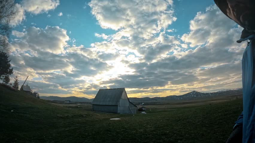 4K timelapse of agricultural farm house with moving clouds and sun