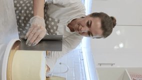 cook a cake in the kitchen. Young female pastry chef cooking a beautiful high sponge cake, pastry chef works at home, bright kitchen, video of the process
