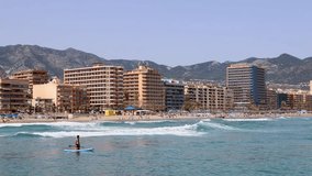 Footage of the beautiful beach in the town of Fuengirola, Malaga, Spain showing holiday makers on the beach known locally as Playa de los Boliches relaxing and having fun,