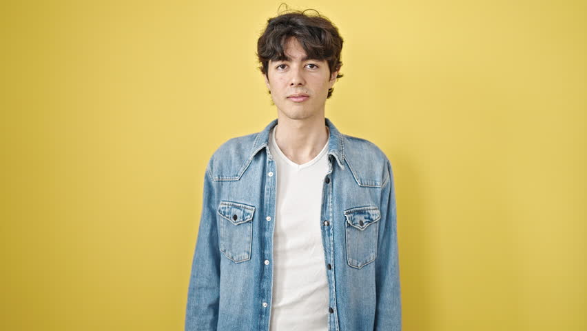 Young hispanic man smiling confident standing over isolated yellow background