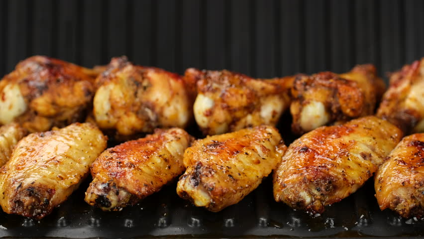 Fry chicken wings on grill, close up