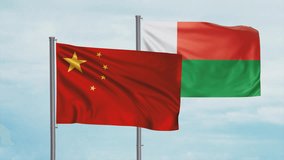 Madagascar flag and China flag waving together on blue sky, looped video, two country cooperation concept