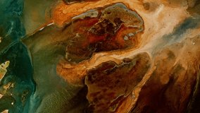 Abstract video of brown colors and greens, in the style of saturated pigment and organic formations. Fluid art with naturalistic landscape background. Liquid formation with swirling acrylics paints.