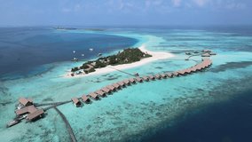 Camera drone flies toward Makunufushi Island with a hotel resort, Maldives