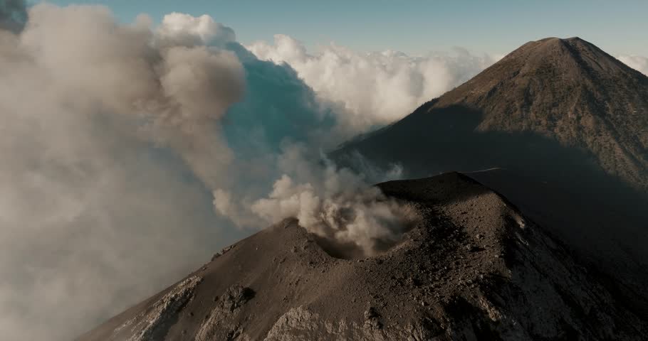Fuego Volcano Spewing Volcanic Ashes And Smog With Agua Volcano In Distance In Guatemala. aerial