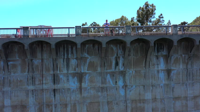 Drone image of Lake Hollywood Reservoir built by Mulholland Dam in 1924 is surrounded by a recreational path for biking, jogging, walking. 
