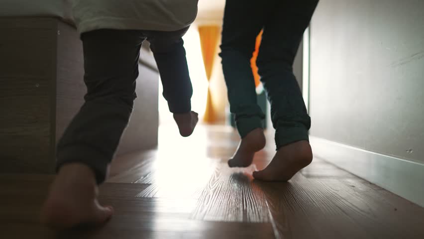 Happy family. Small children run barefoot on warm floor of house. Cheerful children play in new house. Happy children have fun running barefoot. Royalty-Free Stock Footage #1104907551