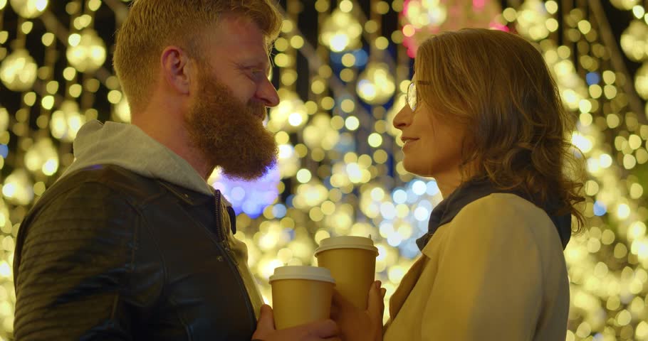 Middle aged couple - love on the Christmas eve. Loving couple enjoy each other at Christmas night. Close-up video of a loving middle aged couple looking each onter. Slow motion 4k video.