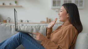 Asian relaxed woman girl on sofa couch at home kitchen talk laptop video meeting online conference talking with friend internet communication chinese businesswoman student smiling speaking side view - Powered by Shutterstock - Get 15% off with code: PIKWIZARD15