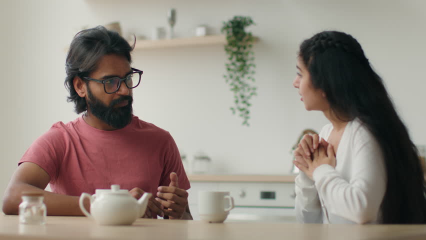 Family conflict couple quarrel Arabian Indian husband and wife arguing talking in home kitchen stressed annoyed man and woman talk loud solve disagreement misunderstanding argue relationship problem