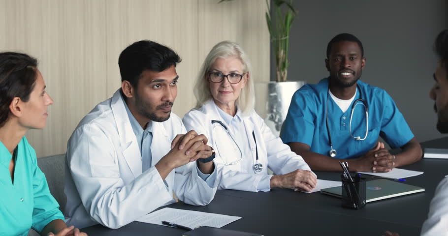 Two young men physicians in white coats accomplish group meeting, medical council of professionals with hands shake, express respect for cooperation, gratitude for successful collaboration or teamwork Royalty-Free Stock Footage #1104912025