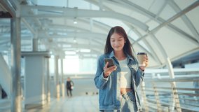 Young asian woman walking with mobile phone and coffee cup in city, Cheerful woman relaxing with cellphone and hot drink outdoors. - Powered by Shutterstock - Get 15% off with code: PIKWIZARD15