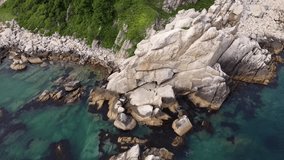 Rocky shore of an uninhabited island in the Sea of Japan, drone video , blue clear water