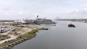 Barge and shipyard in Mobile Bay in Mobile, Alabama with drone video moving in.