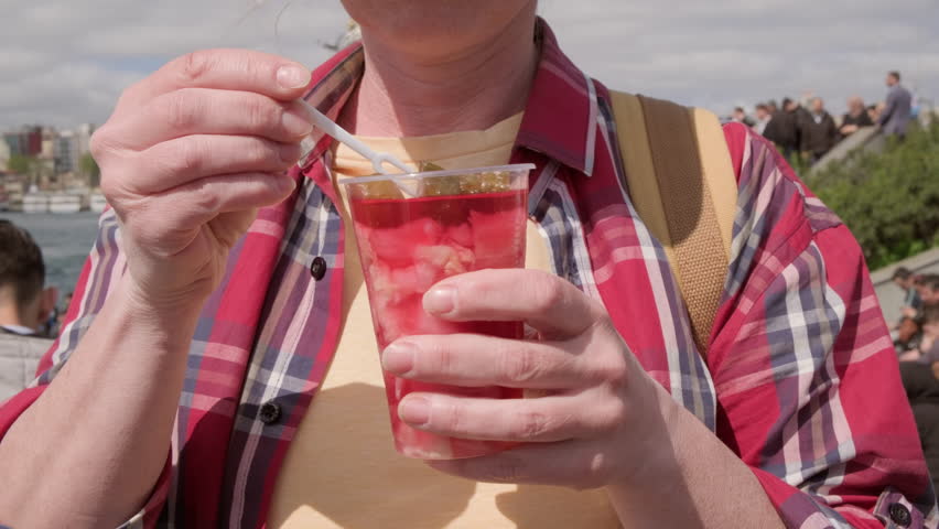 Woman eating pickled cucumbers and cabbage in brine.