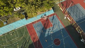 People practicing basketball at club of Buenos Aires city, Argentina. Aerial top-down orbiting at sunset