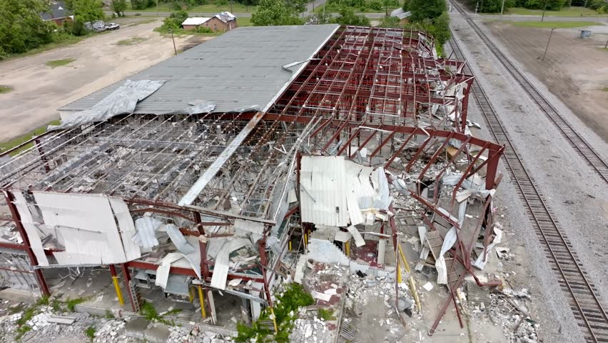 2023 Tornado damage of warehouse in Selma, Alabama with drone pulling back.