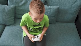 Kid Plays Console. Baby Boy Presses Joystick. Domestic Life and Leisure Activity. Computer and Video Game. Boy Hands on a Controller Playing Video Games. Child Boy Playing Console Game on at Home