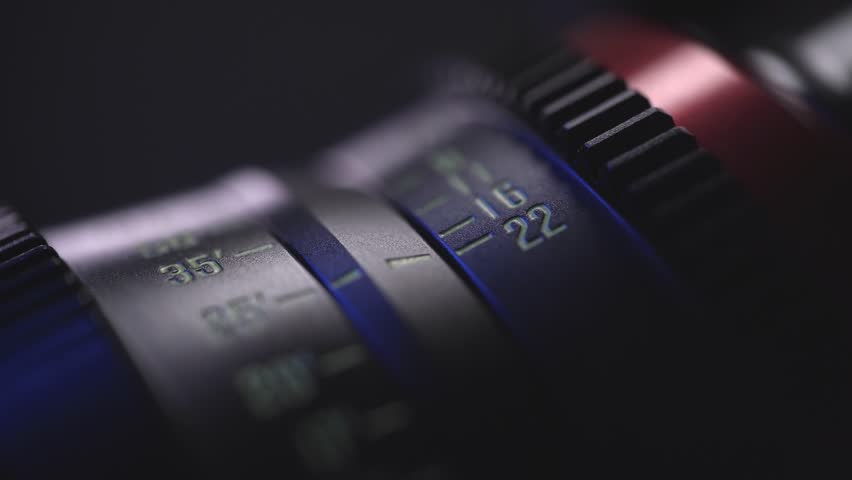 camera lens close-up of the dial with blue light in the background and blurred lens background, anamorphic lens, macro photography, video art