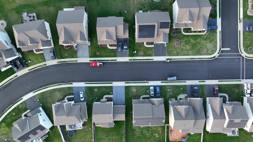 Top down truck shot in American neighborhood. Many houses with solar panel arrays. Establishing drone aerial shot in USA. Royalty-Free Stock Footage #1104946457
