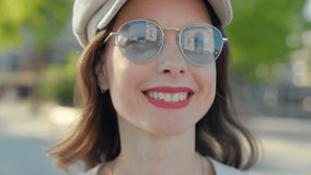 Smiling young girl looking at Arc de Triomphe reflected in sunglasses