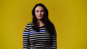 4k video of one woman posing for a video over yellow background.