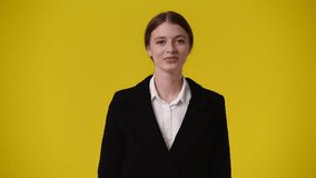 4k video of one girl says hello to someone over yellow background.