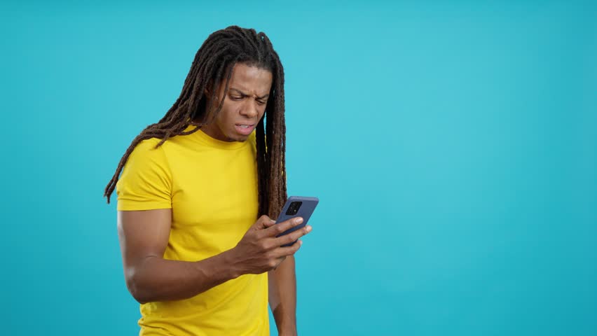 Worried latin man with dreadlocks using a mobile phone Royalty-Free Stock Footage #1104949559
