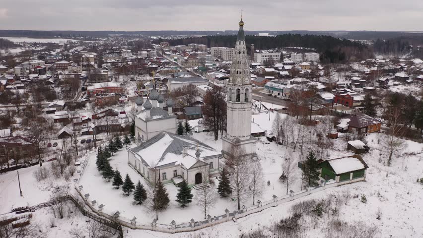 Drone footage of an old Orthodox church with a bell tower in winter. Russian province.
