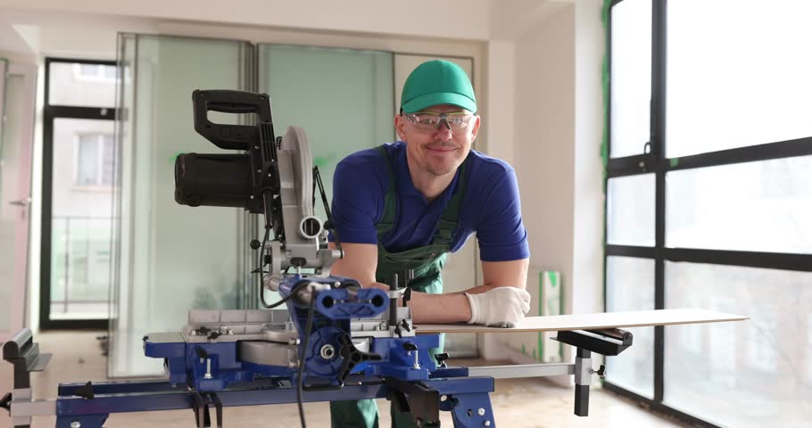 Smiling foreman carpenter working in workshop with circular saw