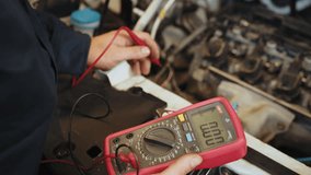 Man using multimeter to measure the voltage of the batteries. Mechanic doing car inspection, he is testing car battery with tester. Check battery voltage with electric multimeter - Powered by Shutterstock - Get 15% off with code: PIKWIZARD15