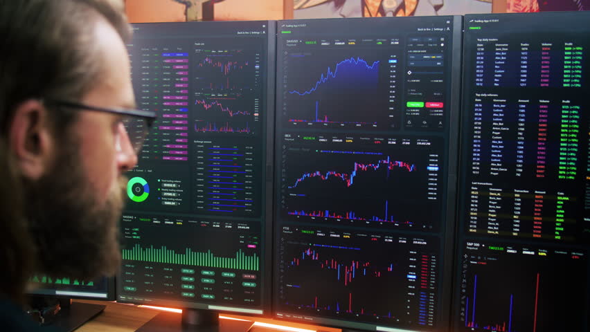 Focused trader, analyst looks at computer screen with multiple monitors, analyzes real-time stocks, exchange market charts. Man works remotely in investment at home office. Cryptocurrency trading. Royalty-Free Stock Footage #1104955349