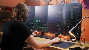 Concentrated trader watches real-time stocks, exchange market charts on multi-monitor computer workstation, types on keyboard. Man works remotely in investment at home office. Cryptocurrency trading. - Powered by Shutterstock - Get 15% off with code: PIKWIZARD15