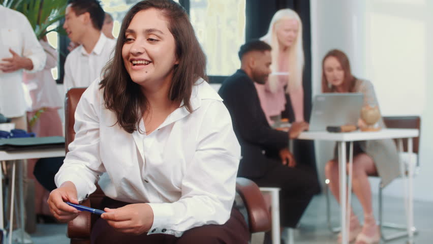 Portrait of confident young female start up owner pitching idea to client and smling in light office setting