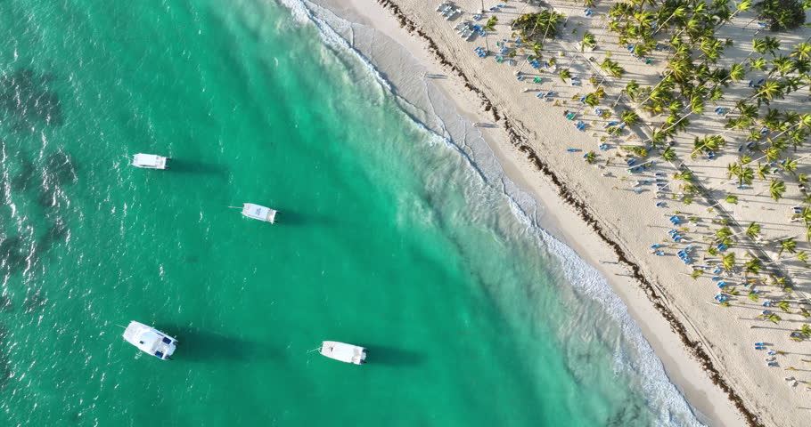 Aerial sunrise panoramic view over exotic beach shore of Bavaro, Punta Cana, Dominican Republic and caribbean sea with sailing catamaran boats