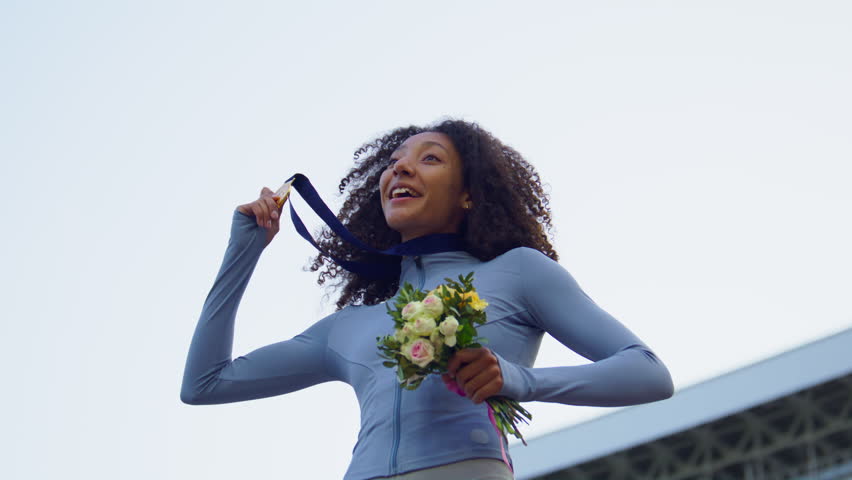 Young African-American Female Athlete Celebrates a Win on a podium, receives a gold medal Royalty-Free Stock Footage #1104968457